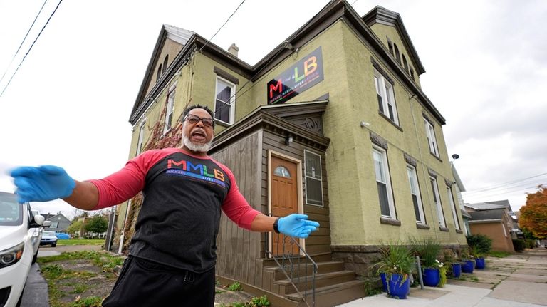 Small business owner Michael Hooks stands outside his building that...